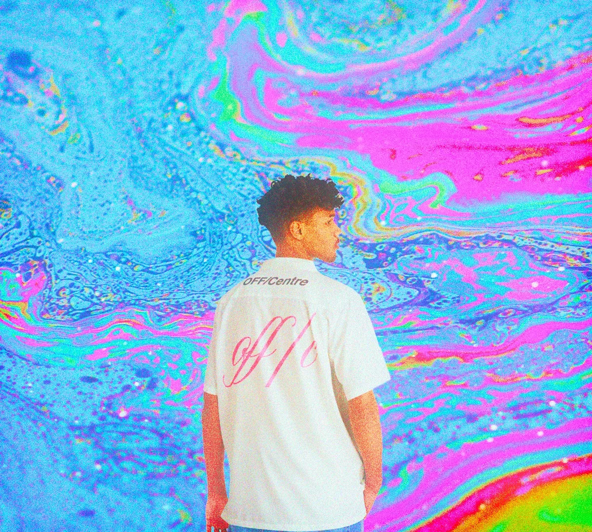 A person standing with their back facing the camera, wearing a white OFF/Centre shirt, against a colorful abstract background with swirling pink, blue, and purple patterns.